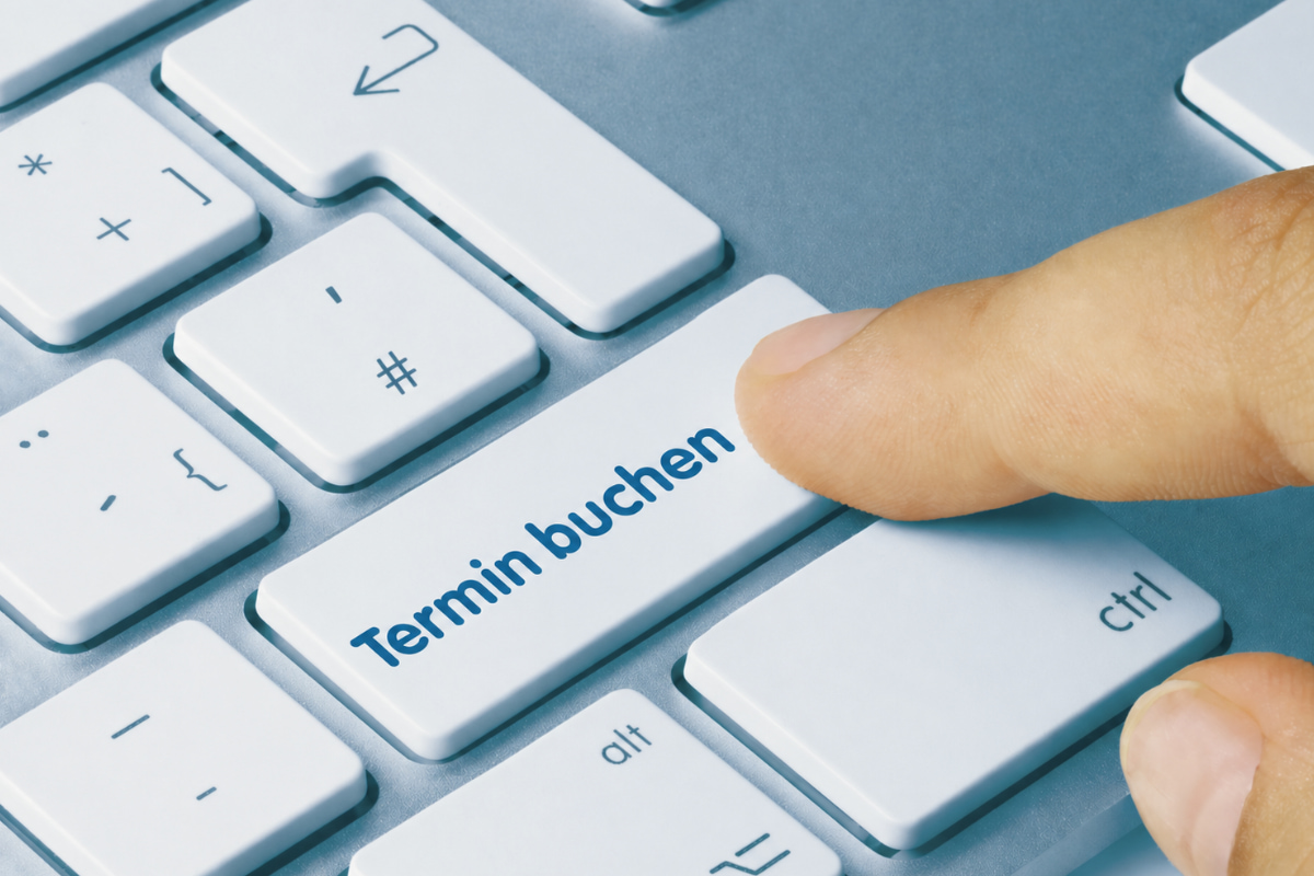 Eine Tastatur mit der Taste "Terminbuchung". Ein Finger ist dabei, die Taste zu drücken.